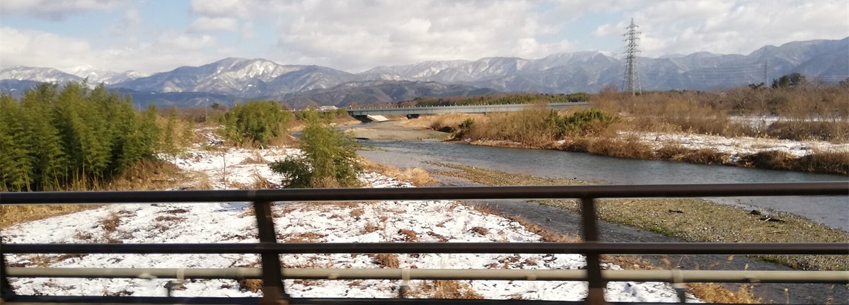 冬の晴れた日に国友橋から見た姉川。雪の残る河原と、遠くの山なみ