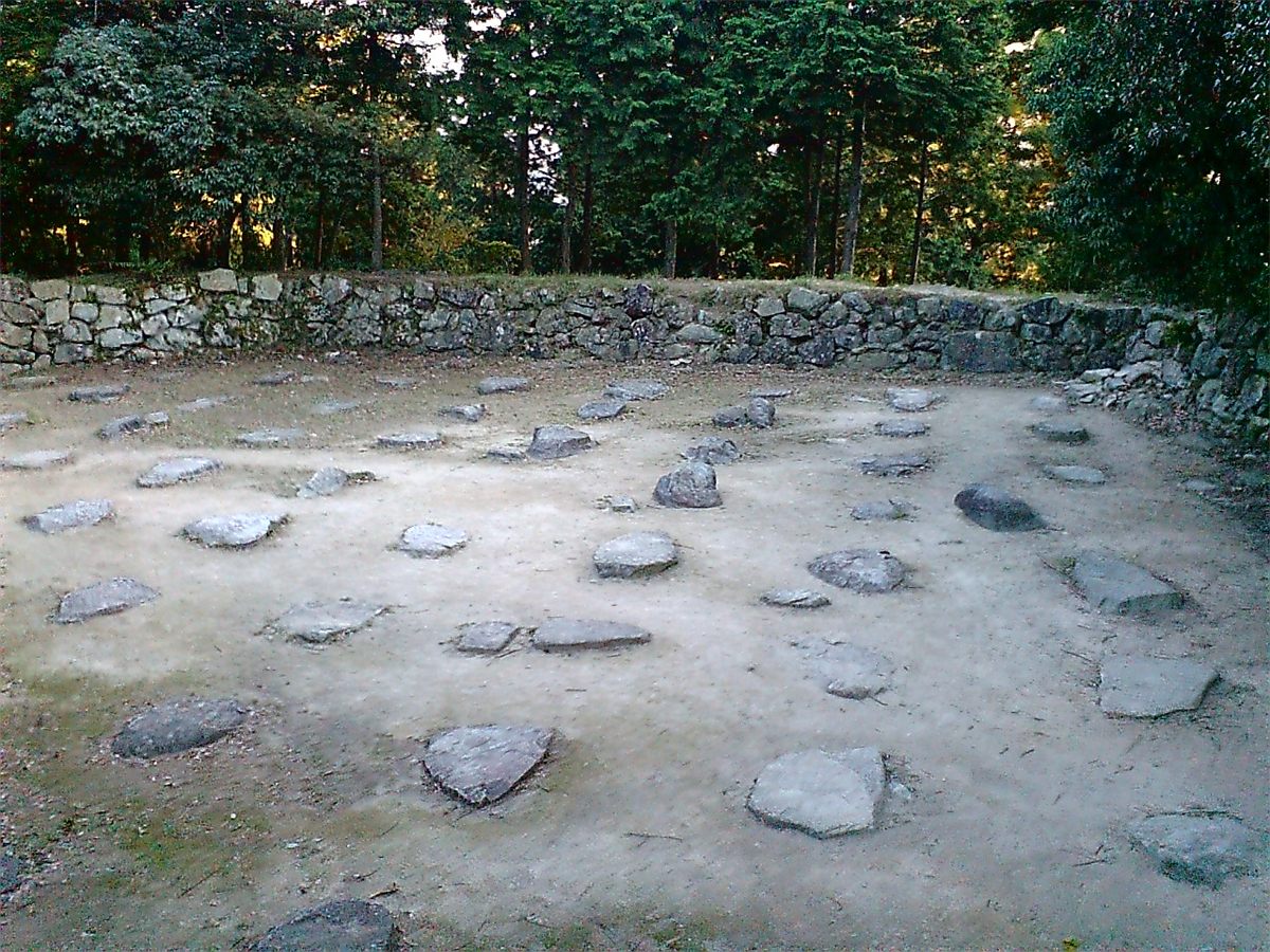 木々に囲まれた安土城の天主台のあと。地面に礎石が並んでいる