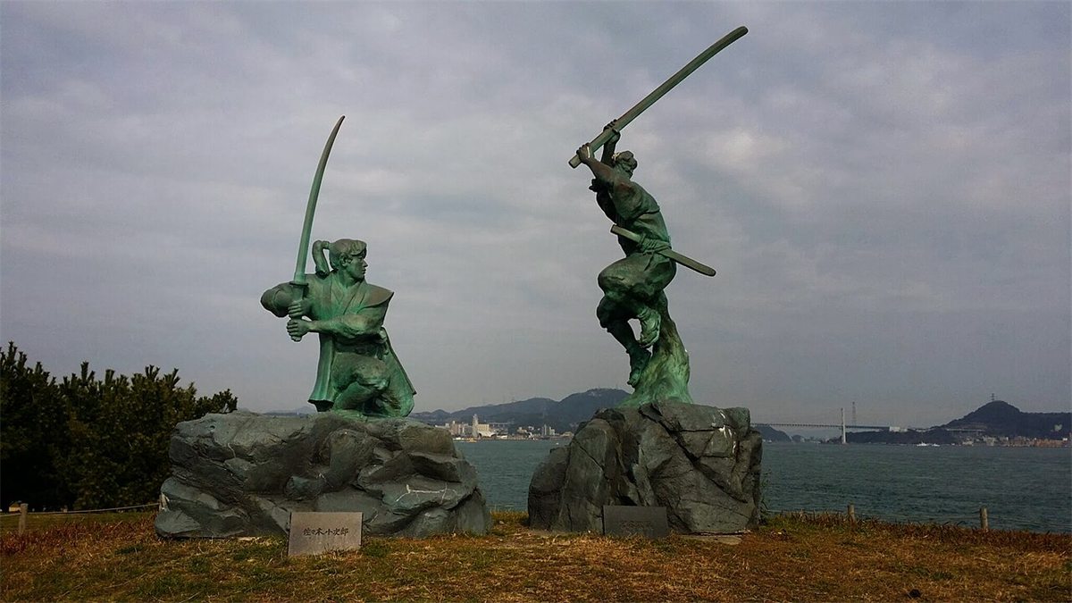 Two bronze statues on Ganryujima showing Miyamoto Musashi and Sasaki Kojiro in the middle of their duel