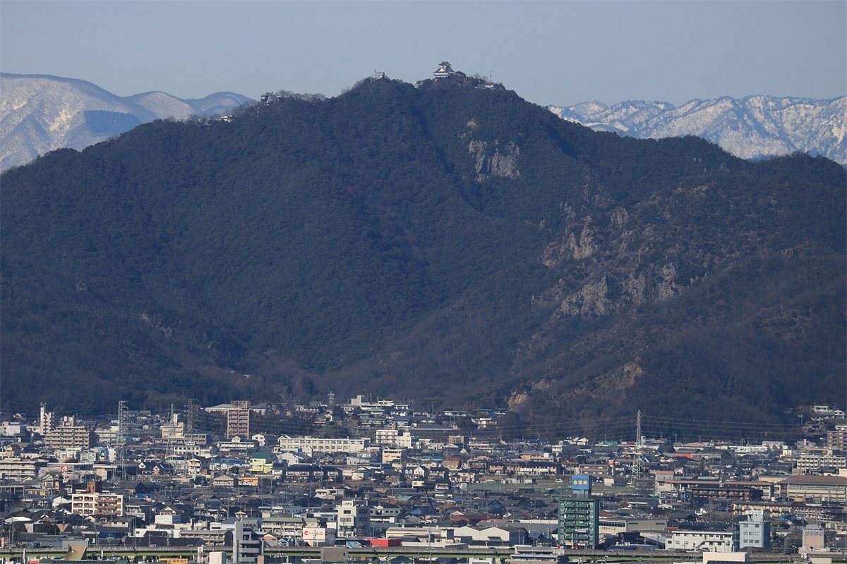 岐阜市の街の向こうにそびえる金華山。山頂に岐阜城の天守が見える