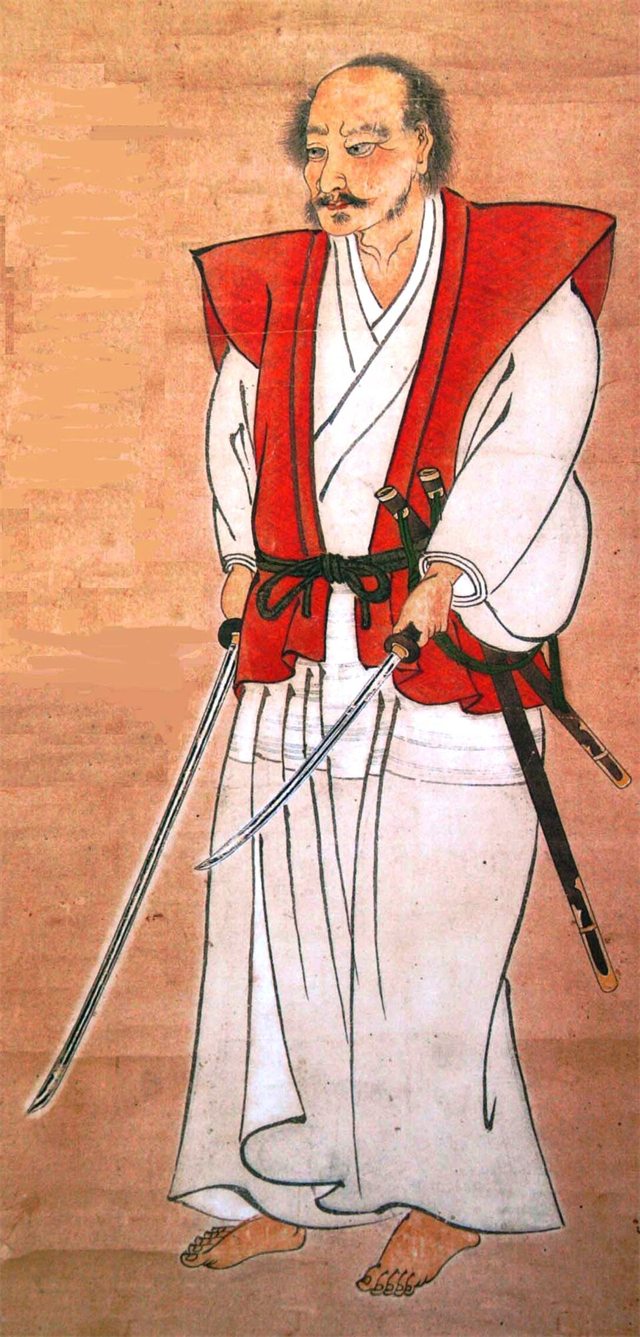 Portrait of Miyamoto Musashi standing with a sword lowered in each hand, held at the Shimada Museum of Art