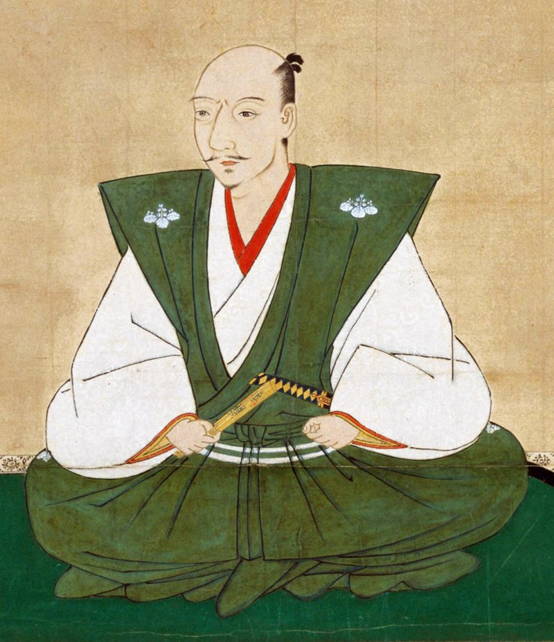 緑の肩衣と袴を着て、扇を手に座る織田信長の肖像画